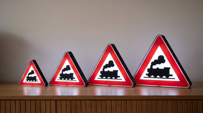 Vier Bahnuebergang-Lampen in 22, 32, 42 und 52 cm nebeneinander auf einem Sideboard